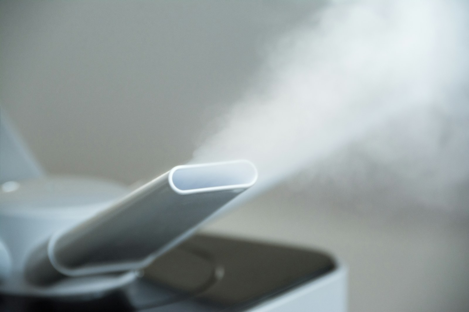 Close-up do bocal de um vaporizador a libertar um jacto denso de vapor branco quente.